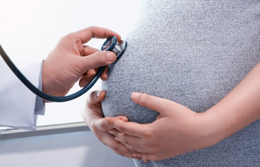 Stéthoscope posé sur le ventre d'une femme enceinte pendant une consultation prénatale